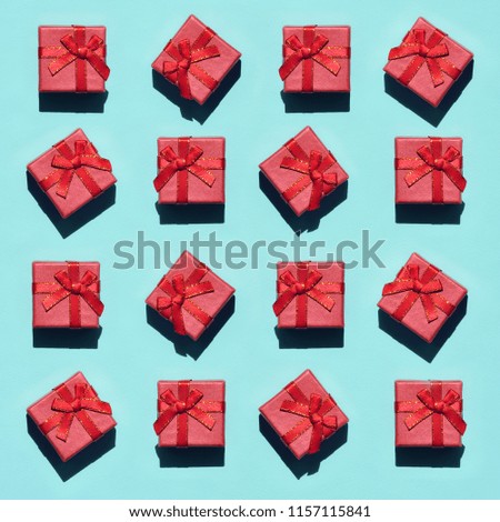 Many small red pink gift boxes on texture background of fashion trendy pastel blue color paper in minimal concept. Abstract pattern
