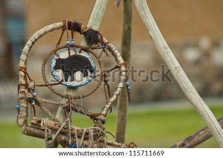 A handmade dreamcatcher hangs on a teepee. Royalty-Free Stock Photo #115711669