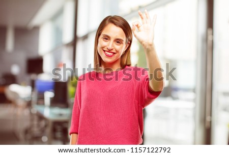 young woman full body. making an "alright" or "okay" gesture approvingly with hand, looking happy and satisfied. Positive check sign.