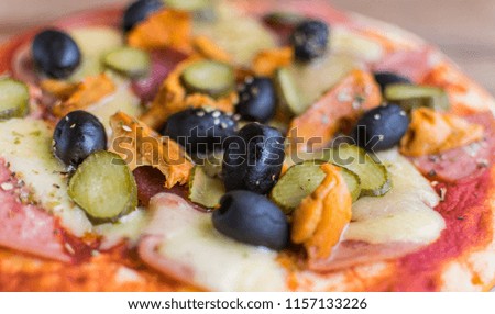 full frame photo of pizza made of olives, ham, cheese , cucumbers, mushrooms. Selective focus