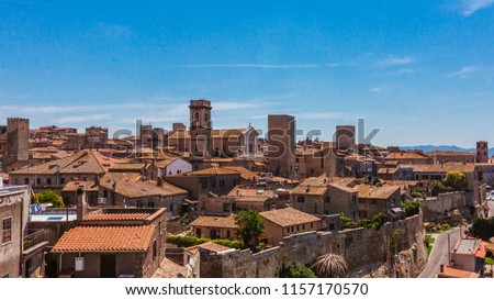 Panoramic view of the architecture and houses of the old town of Tarquinia, Italy under blue sky Royalty-Free Stock Photo #1157170570