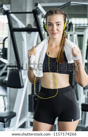 Woman Listening Music, Doing Workout Exercises.Relaxing After Fitness Training in gym.She smile and happy.