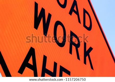 Road work ahead sign close up abstract with a blue sky edge
