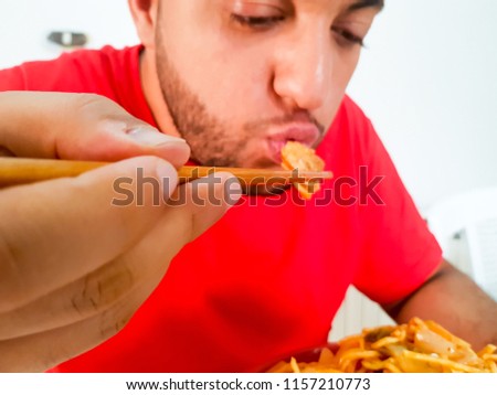 Man eating noodles happily