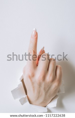 girl hand breaks white paper and shows a gesture.