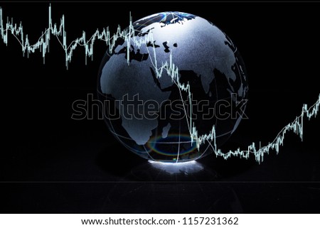 Glass globe with financial reports and graphs