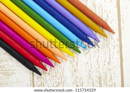 twelve color pastel crayon  in box close up with woody texture background