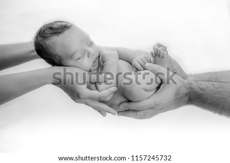 Cute newborn baby sleeps in the hands of parents protected and safe - happy family moments for mom and dad