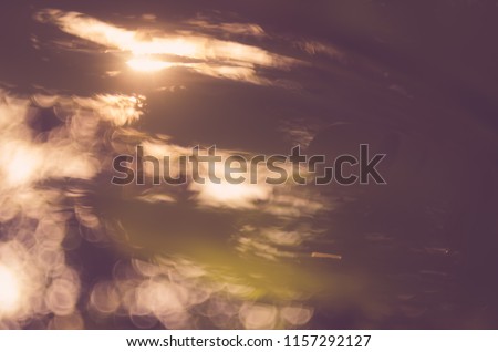 Copy space of blur palm leaf tree on sunset sky and white clouds with bokeh sun ligth abstract texture background. Ecology and environment concept. Vintage tone filter effect color style.