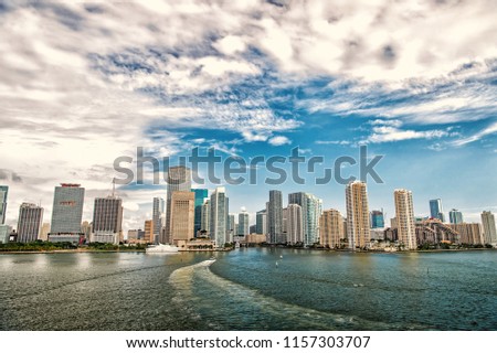 Aerial view of Miami skyscrapers with blue cloudy sky,white boat sailing next to Miami downtown. miami skyline