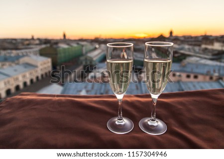 champagne glasses on a sunset city background 