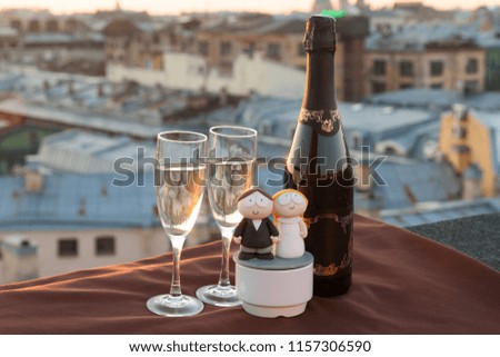 champagne on a sunset rooftop background with funny wedding figures