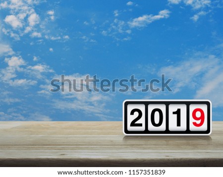 Retro flip clock with 2019 text on wooden table over blue sky with white clouds, Business happy new year concept