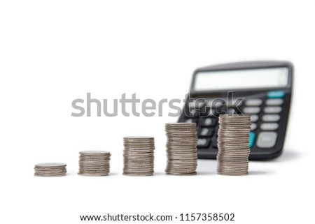 Coin stacks and calculator on a white background.
