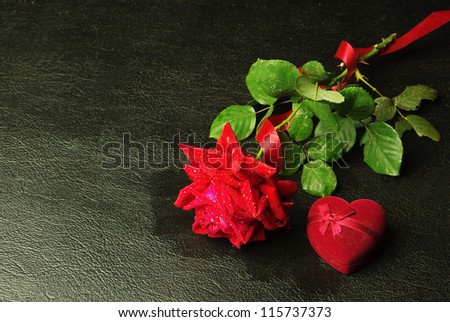 Red rose and gift. Black background