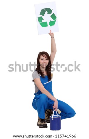 Female painter holding sign with symbol of recycling