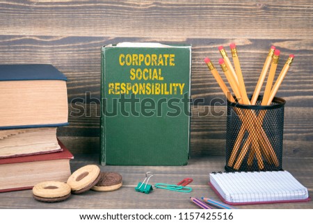Corporate Social Responsibility concept. Book on a wooden background