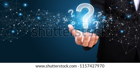 businesswoman on blurred background holding hand question marks. Royalty-Free Stock Photo #1157427970