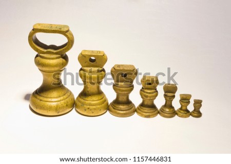Brass Kitchen weights lined-up on white background