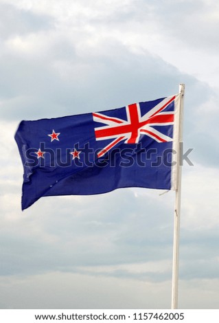 New Zealand flag on a blue sky with clouds background