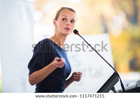 Pretty, young business woman giving a presentation in a conference/meeting setting (shallow DOF; color toned image) Royalty-Free Stock Photo #1157471215