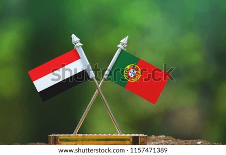 Portugal and Yemen small flag with blur green background