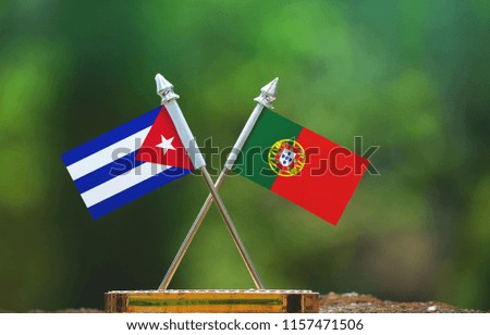 Portugal and Cuba small flag with blur green background