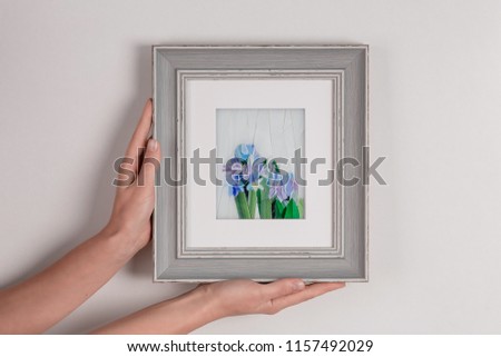 Woman holding in hands mosaic picture in a frame.