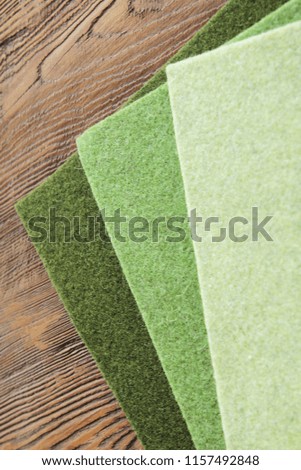 Cloth. Three shades of green on a wooden background
