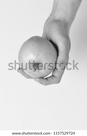 Male hand holds light green apple. Apple placed on white background, copy space. Apple in fresh and juicy color. Food and dieting concept.
