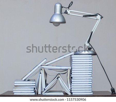 Books and a desk lamp on a table