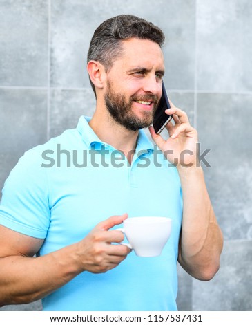 Man drink cappuccino speak phone grey wall background. Coffee can be endlessly reimagined make something old new again like entrepreneurs craft and reinvent businesses. Pleasant coffee break at work.