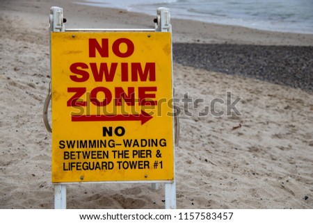 A No Swim Sign Next to the Pier in San Clemente, CA 