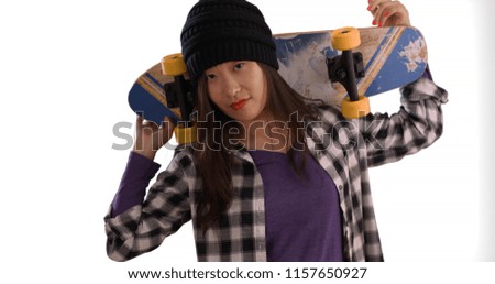Close view of millennial woman holding skateboard on shoulders on copy space