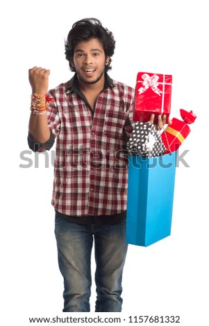 Young men showing rakhi on his hand with shopping bags and gift box on the occasion of Raksha Bandhan festival.