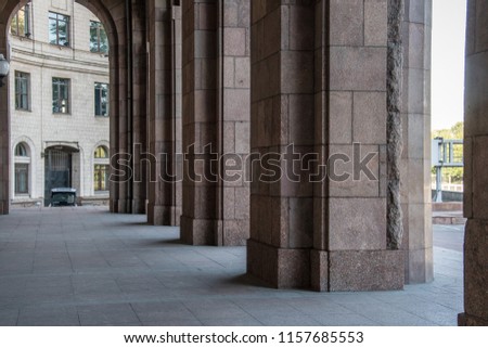 Tall and long corridor with marble columns and floor