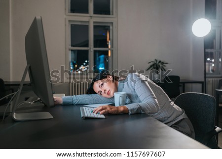 Overworked woman lying on the office desk while working.