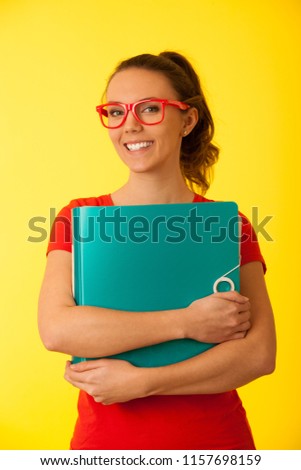 Young happy excited geek woman in red t shirt over vibrant yellow background