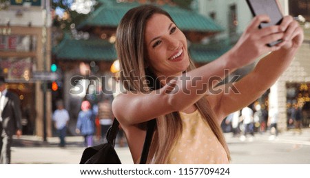 Woman in her 20s taking photo of herself with phone in San Francisco Chinatown