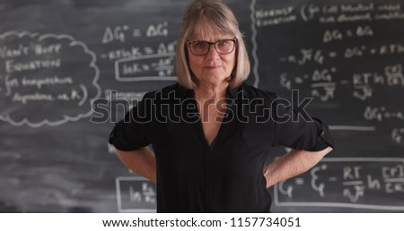 Old senior woman teacher with serious attitude posing in front of chalkboard Royalty-Free Stock Photo #1157734051