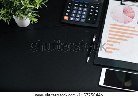 Black desk with computer graph and calculator Of businessmen in the office.