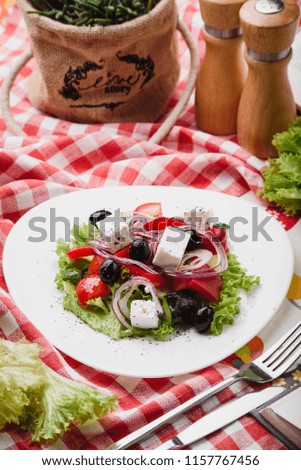 Greek salad on a white plate on red napkins in a square. Close up. series of photos