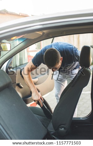 Man cleaning interior of his car