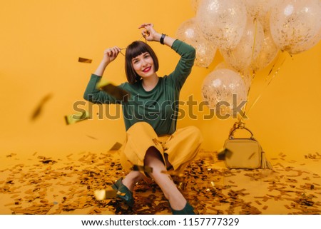 Wonderful girl with hair accessory posing on yellow background. Studio shot of ecstatic brunette lady having fun in at birthday party.