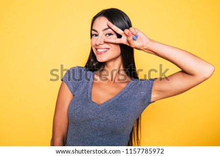 Happy and funny beautiful young woman have a fun and smiling isolated on yellow background. Funny faces. Good mood and perfect day.