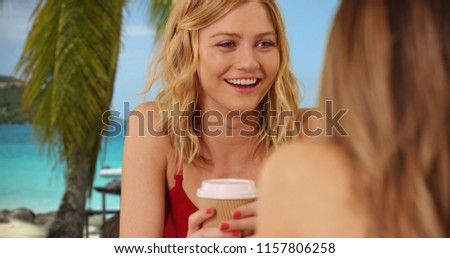 Beautiful blonde being social with friend sitting and drinking in Virgin Islands
