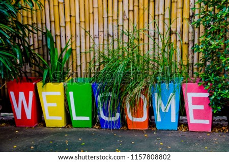 Beautiful color of  the word "Welcome" made from flowerpot on wood bamboo background