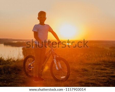 little boy riding bikes at sunset, active kids sport. Space for text