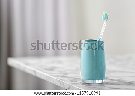 Cup with toothbrush on table. Dental care Royalty-Free Stock Photo #1157910991