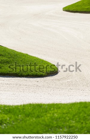 Golf Sand Trap or Bunker with Green Grass and Shallow Depth of Field Background.  Lots of Copy Space